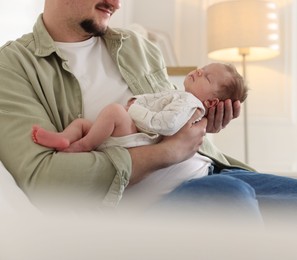 Photo of Father with his cute newborn baby indoors, closeup