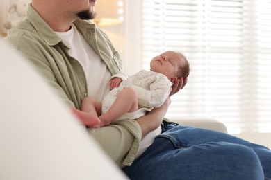 Photo of Father with his cute newborn baby indoors, closeup