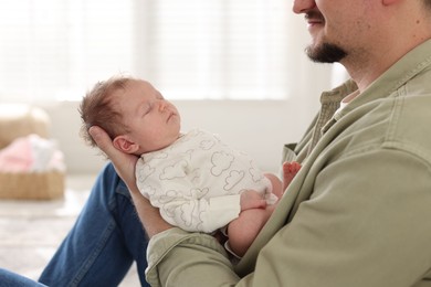Photo of Father with his cute newborn baby indoors, closeup