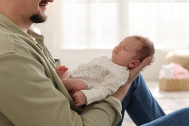 Photo of Father with his cute newborn baby indoors, closeup