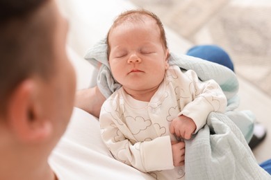 Photo of Father with his cute newborn baby indoors, above view
