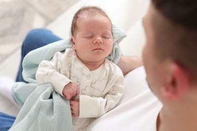 Photo of Father with his cute newborn baby indoors, above view