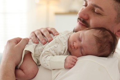 Photo of Father with his cute newborn baby indoors, closeup