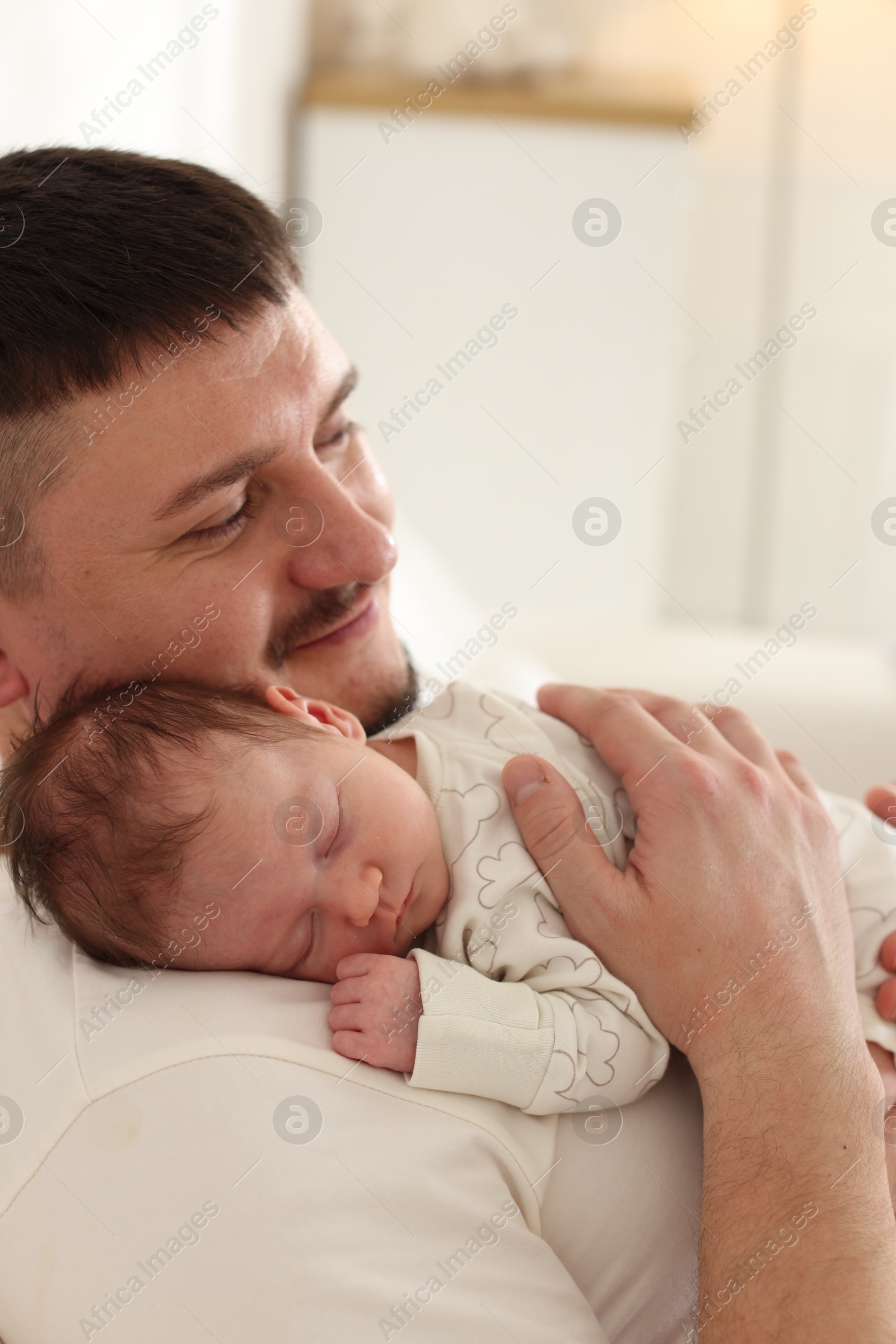 Father with his cute newborn baby indoors Photo of Father with his cute newborn baby indoors