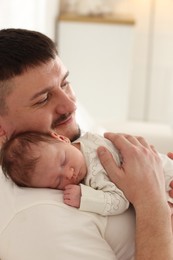 Photo of Father with his cute newborn baby indoors