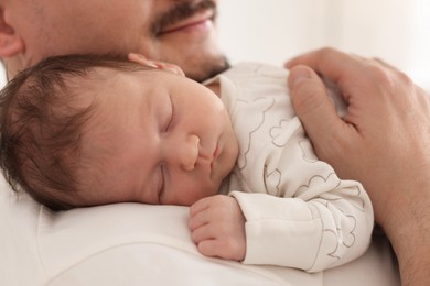 Photo of Father with his cute newborn baby indoors, closeup