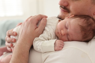 Photo of Father with his cute newborn baby indoors, closeup
