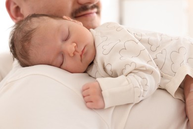 Photo of Father with his cute newborn baby indoors, closeup