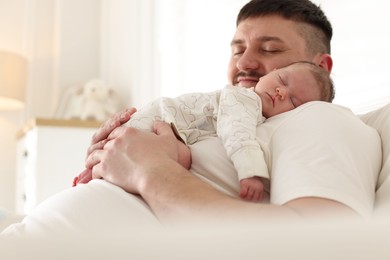 Photo of Father with his cute newborn baby indoors