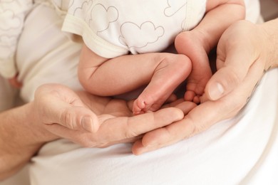 Photo of Father with his cute newborn baby indoors, closeup