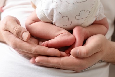 Photo of Father with his cute newborn baby indoors, closeup