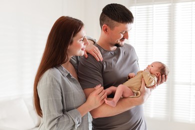 Photo of Happy parents with their cute newborn baby indoors