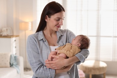 Photo of Mother with her cute newborn baby indoors