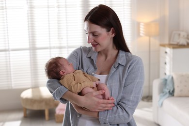 Photo of Mother with her cute newborn baby indoors