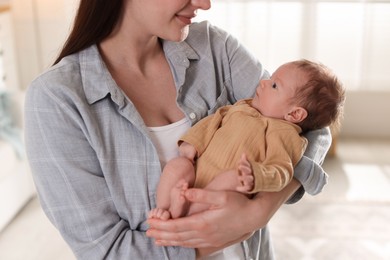 Photo of Mother with her cute newborn baby indoors, closeup