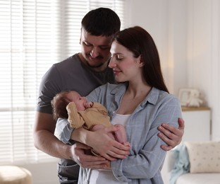 Photo of Happy parents with their cute newborn baby indoors