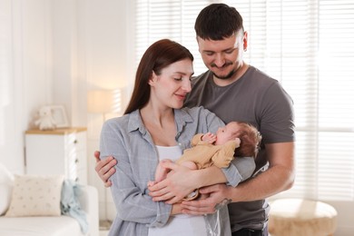 Photo of Happy parents with their cute newborn baby indoors