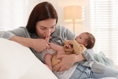 Photo of Mother with her cute newborn baby on sofa indoors