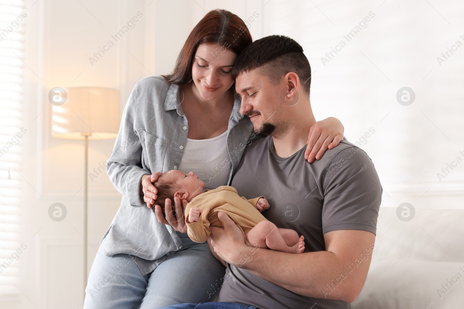Happy parents with their cute newborn baby indoors Photo of Happy parents with their cute newborn baby indoors