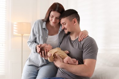 Photo of Happy parents with their cute newborn baby indoors