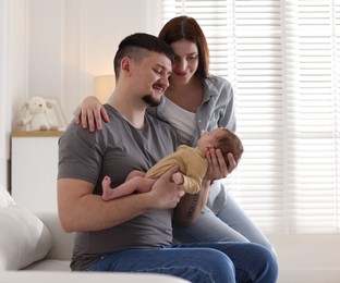 Photo of Happy parents with their cute newborn baby indoors