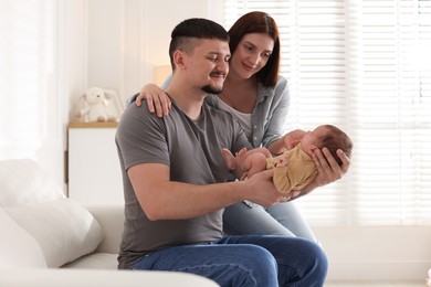 Photo of Happy parents with their cute newborn baby indoors