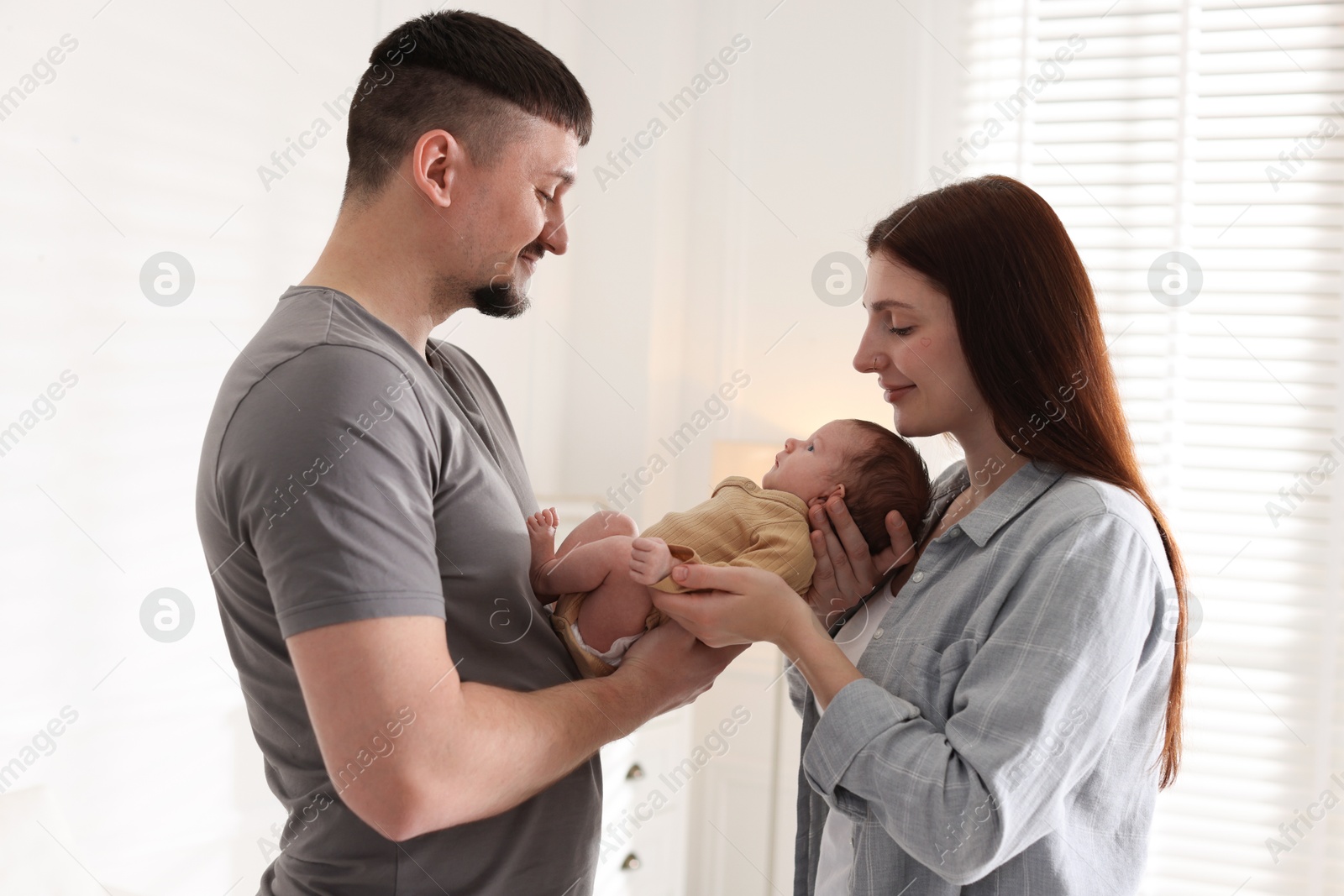 Happy parents with their cute newborn baby indoors Photo of Happy parents with their cute newborn baby indoors