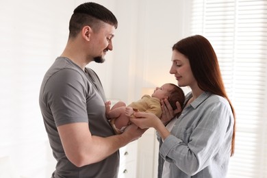Photo of Happy parents with their cute newborn baby indoors