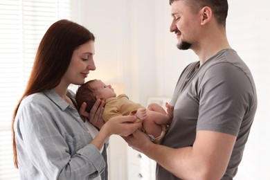 Photo of Happy parents with their cute newborn baby indoors