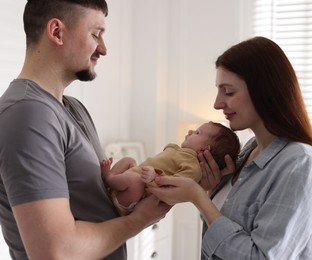 Photo of Happy parents with their cute newborn baby indoors