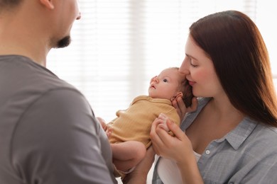 Photo of Parents with their cute newborn baby indoors
