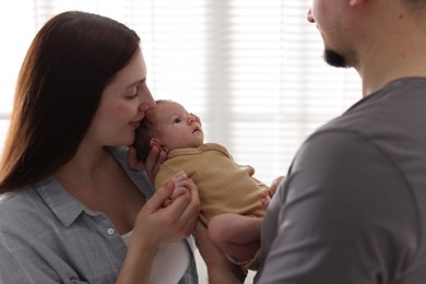 Photo of Parents with their cute newborn baby indoors