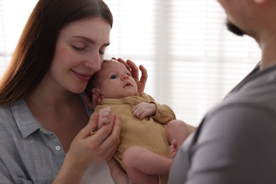 Photo of Parents with their cute newborn baby indoors