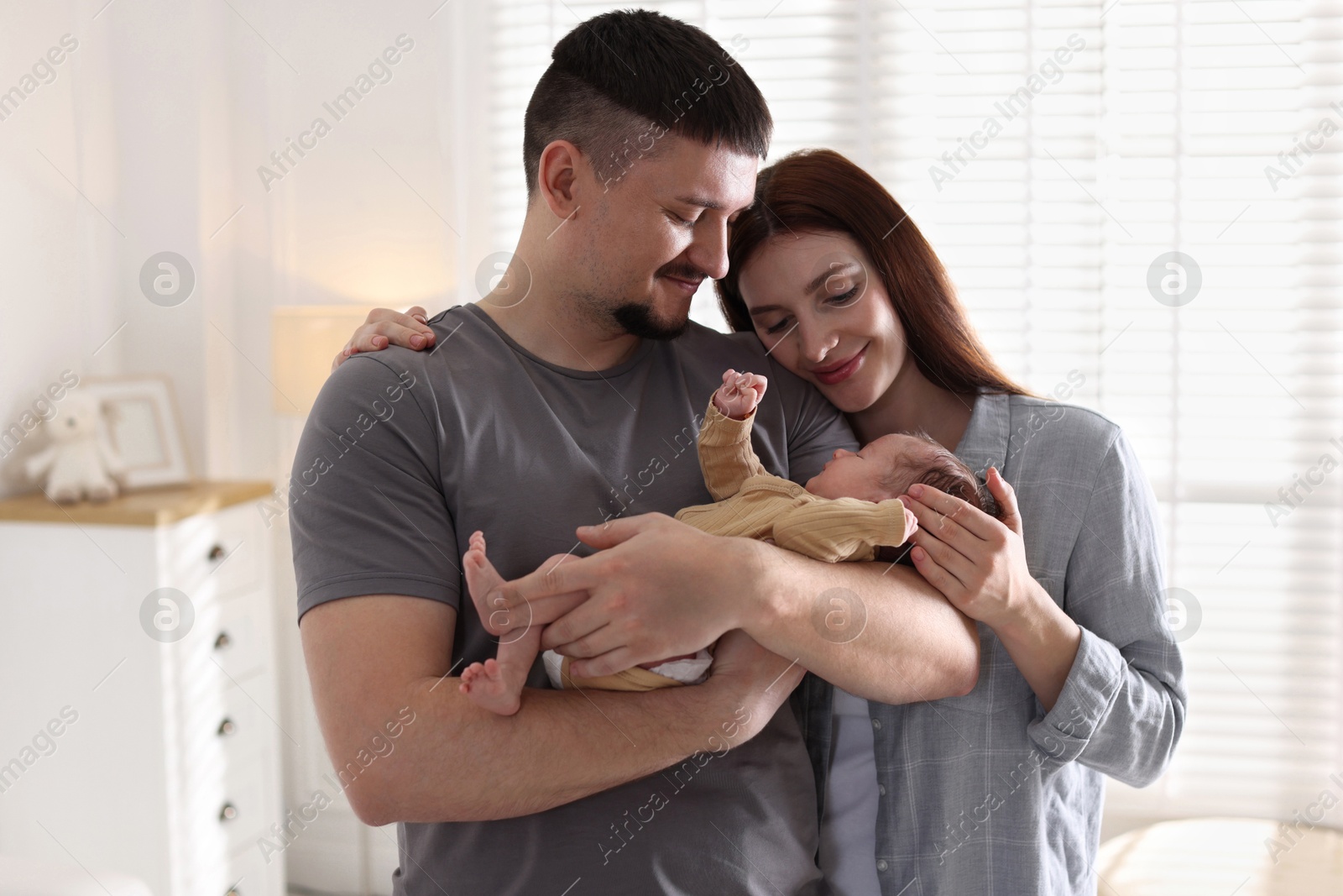 Happy parents with their cute newborn baby indoors Photo of Happy parents with their cute newborn baby indoors