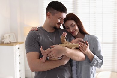 Photo of Happy parents with their cute newborn baby indoors