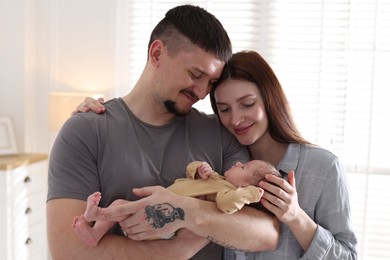 Photo of Happy parents with their cute newborn baby indoors