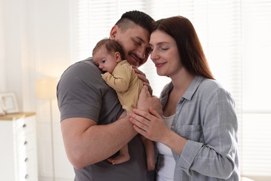 Photo of Happy parents with their cute newborn baby indoors