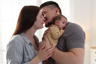 Photo of Happy parents with their cute newborn baby indoors