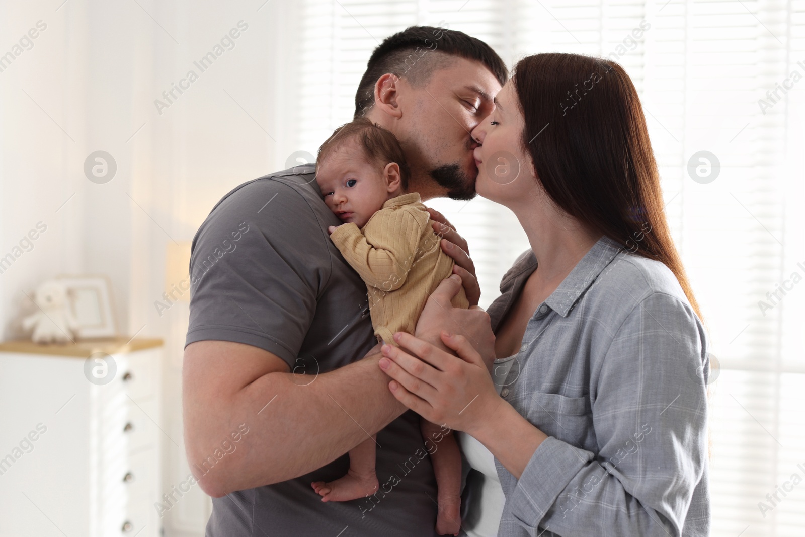 Parents with their cute newborn baby indoors Photo of Parents with their cute newborn baby indoors