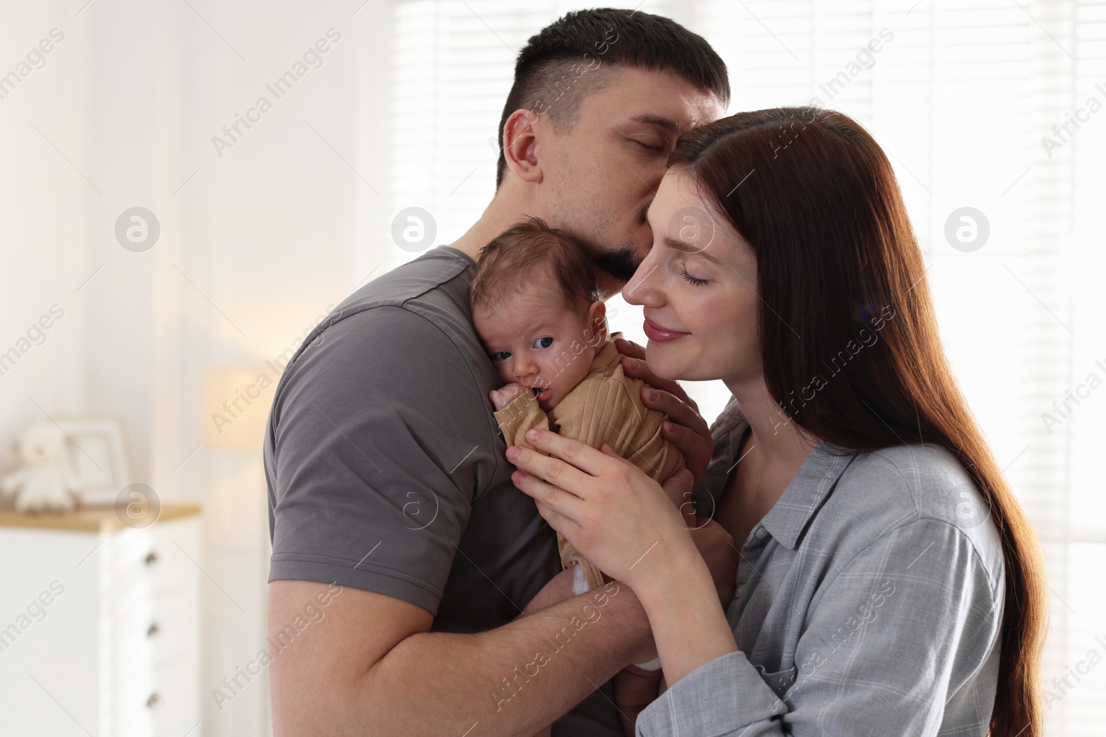 Happy parents with their cute newborn baby indoors Photo of Happy parents with their cute newborn baby indoors