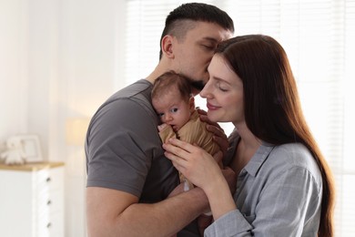 Photo of Happy parents with their cute newborn baby indoors