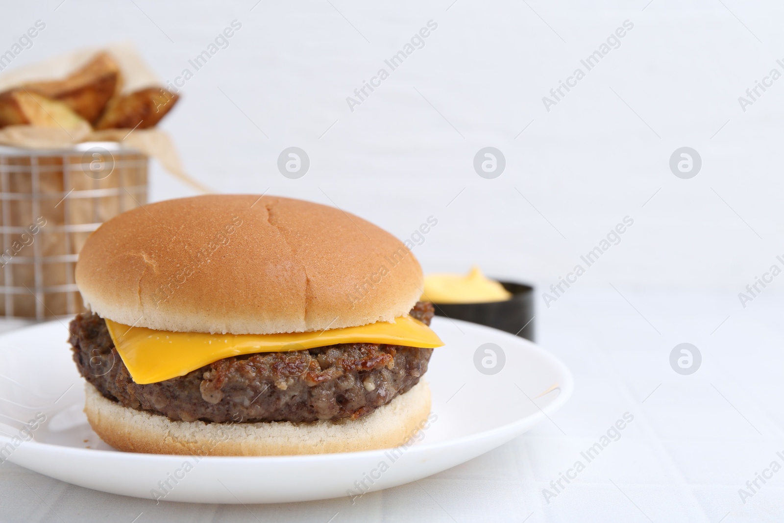 Photo of Cheeseburger with tasty patty on white table, closeup. Space for text