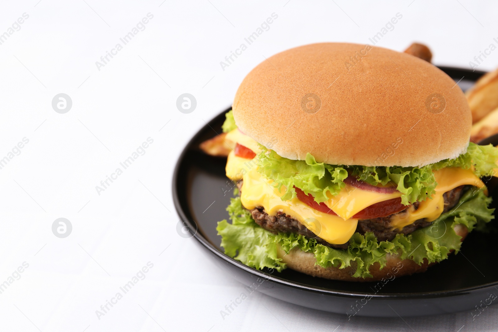 Tasty cheeseburger with sauce on white table, closeup. Space for text Photo of Tasty cheeseburger with sauce on white table, closeup. Space for text