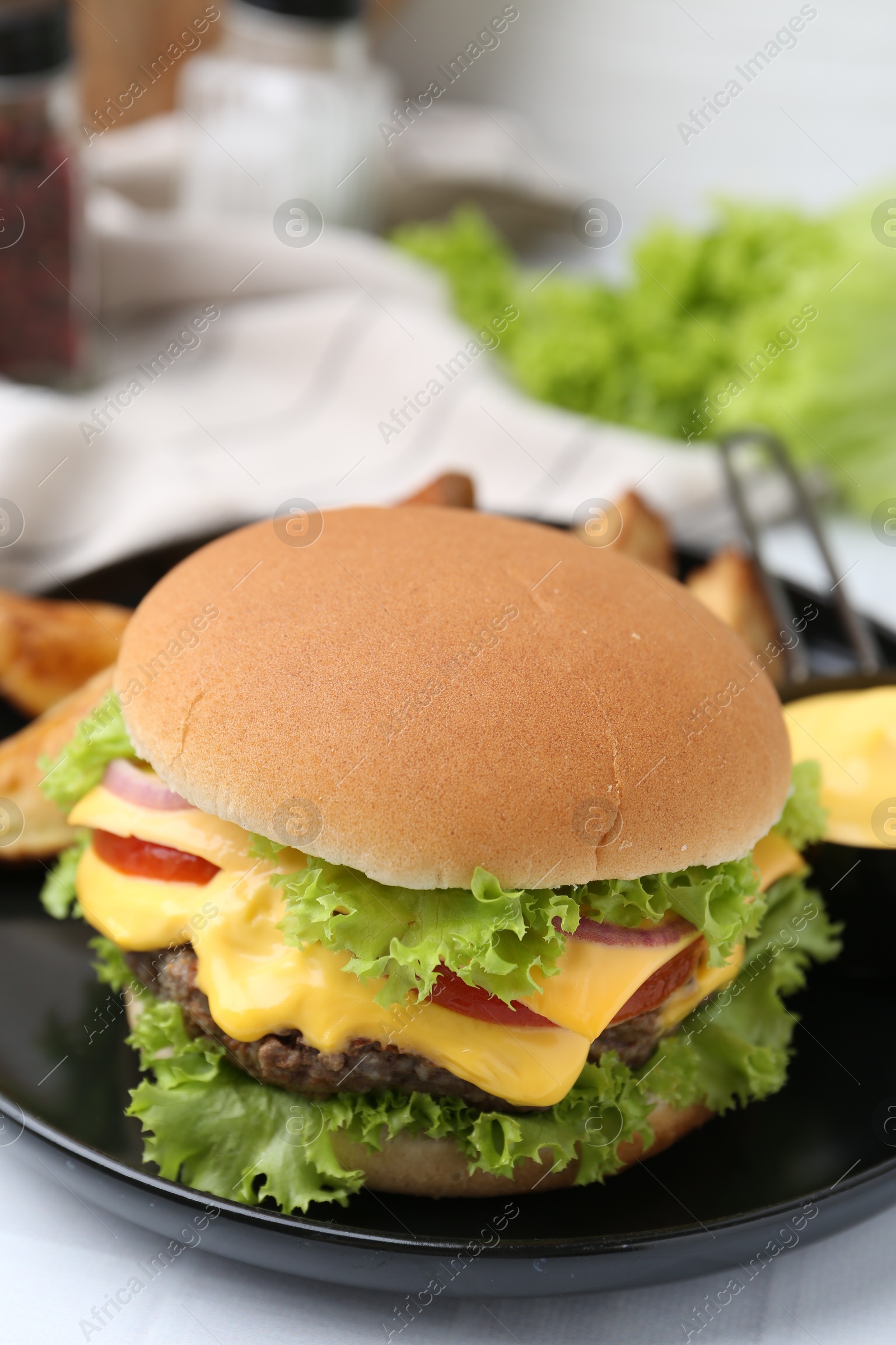 Tasty cheeseburger with sauce on table, closeup Photo of Tasty cheeseburger with sauce on table, closeup