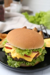 Photo of Tasty cheeseburger with sauce on table, closeup