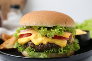 Photo of Tasty cheeseburger with sauce on table, closeup