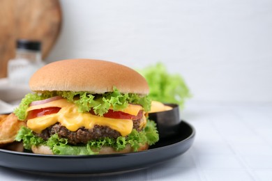 Photo of Tasty cheeseburger with sauce on white table, closeup. Space for text
