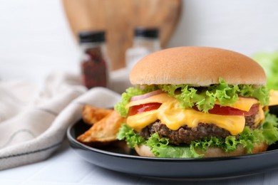 Photo of Tasty cheeseburger with sauce and potato wedges on white table, closeup