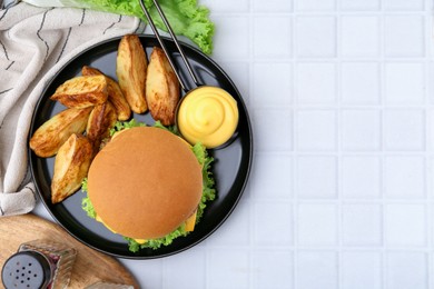 Photo of Tasty cheeseburger with sauce and potato wedges on white tiled table, flat lay. Space for text