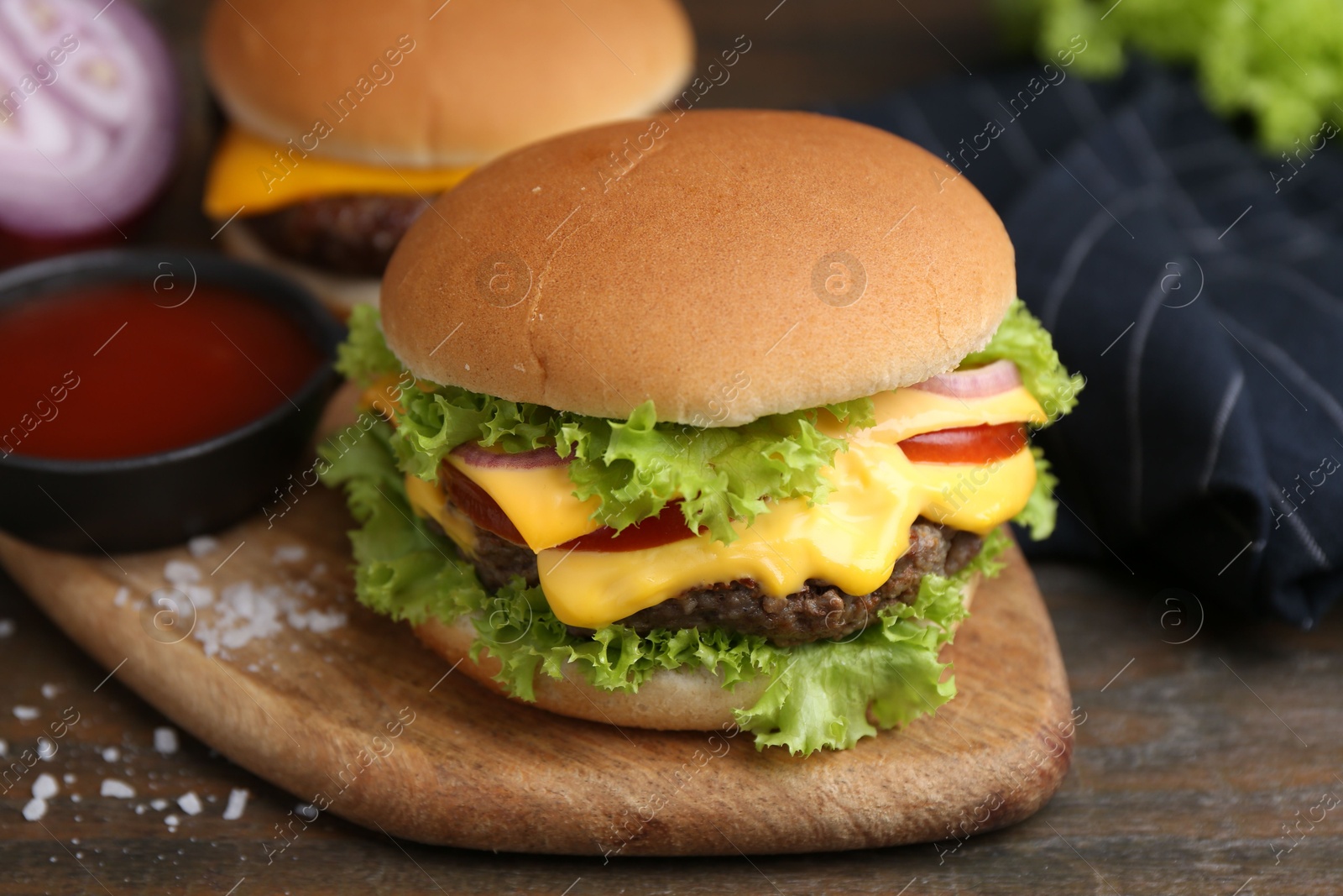 Tasty cheeseburgers served on wooden table, closeup Photo of Tasty cheeseburgers served on wooden table, closeup